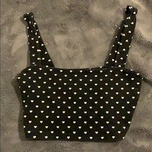 A black crop top with white heart all around it